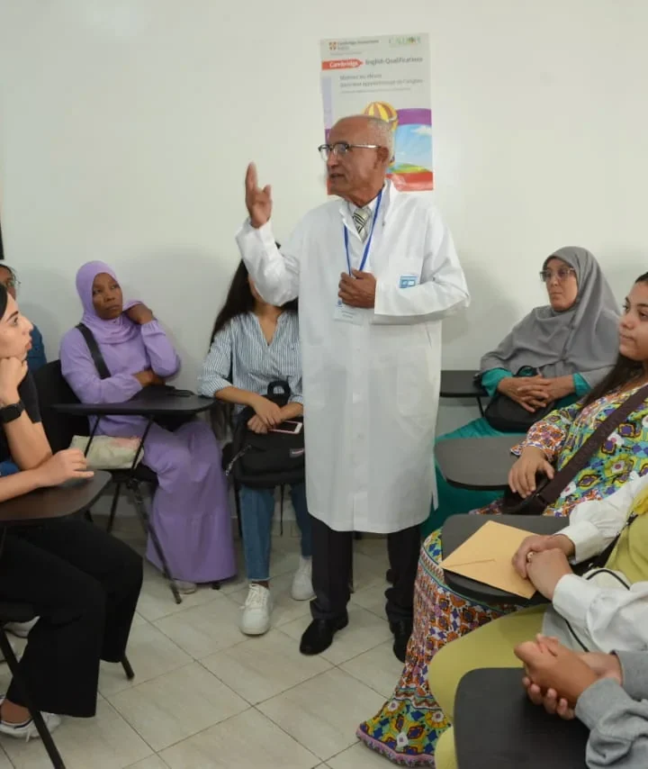 مكوِّن بوزرة بيضاء يقدّم درسًا أمام الطالبات