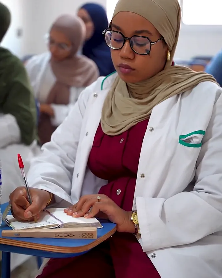 طالبة في ESSP تدوّن ملاحظاتها أثناء الدرس