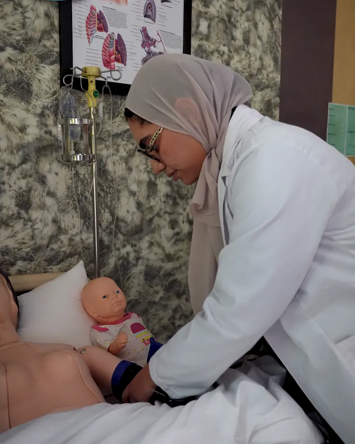 طالبة تتدرّب على العلاج باستعمال دمية تدريب